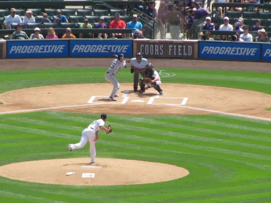 MLB pitcher throws a pitch at Coors Field.