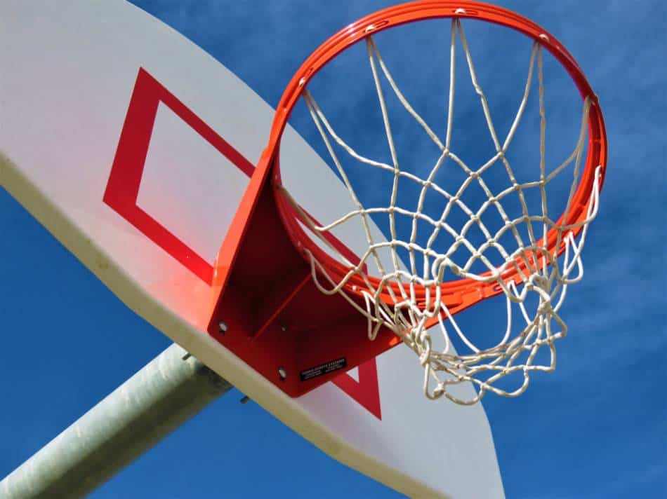 View of a basketball hoop at the park from beneath the rim on a sunny day.