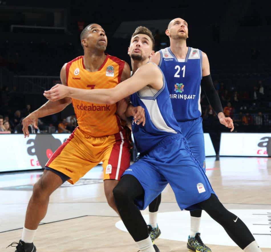 Basketball player in blue and white defenders against a player in orange and red.