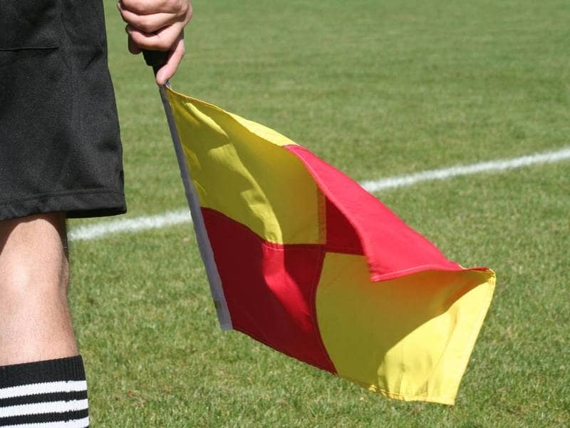 Soccer lineman holds flag.