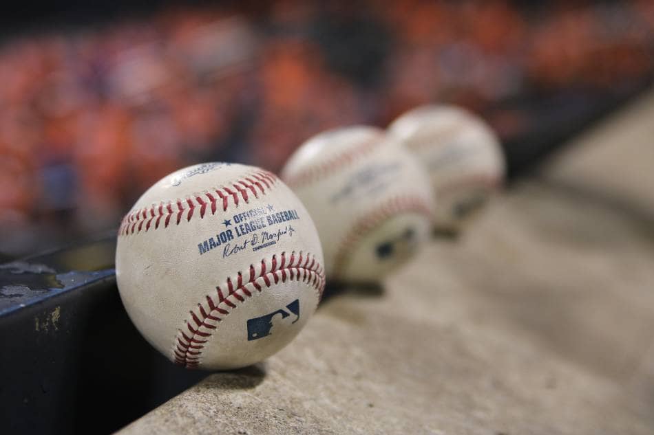 Three baseballs sitting along concrete steps.