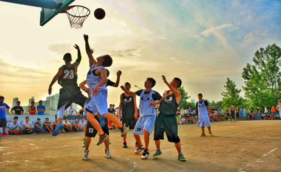  Un jeune basketteur a son tir bloqué dans un match en plein air.