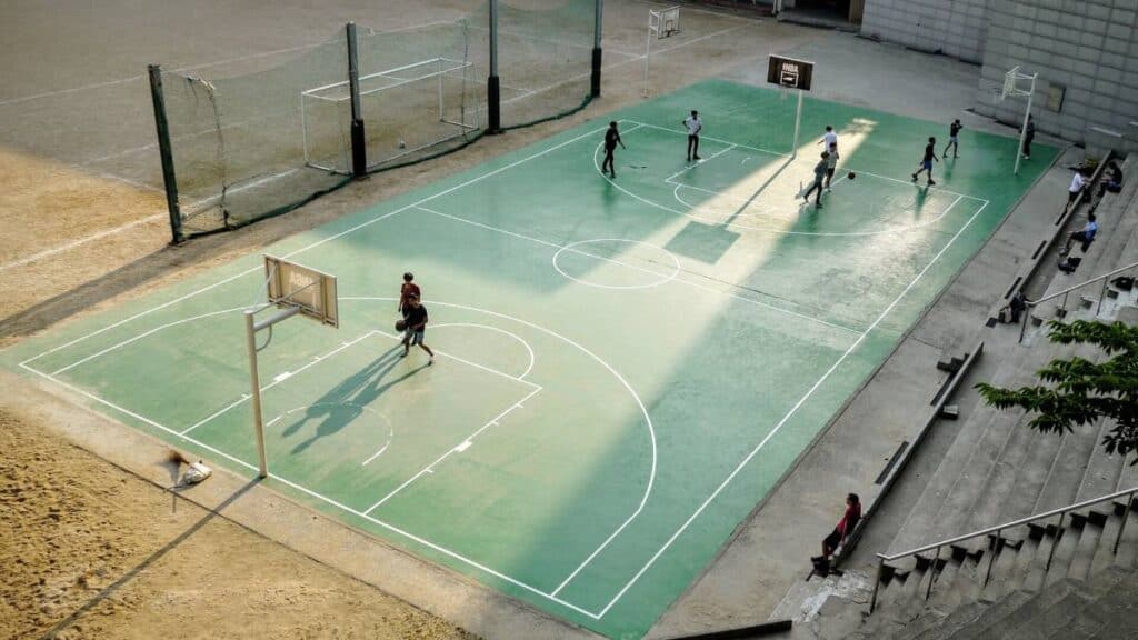 People playing basketball on an outdoor court.