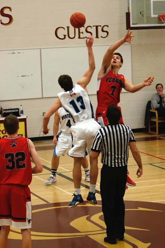 Two high school basketball players participate in a jump ball.