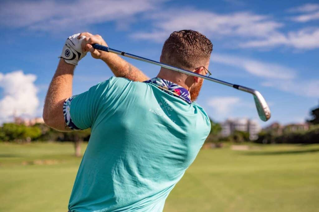 A golfer takes a swing with one of their irons.