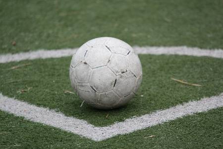 A white soccer ball gets prepared for a corner kick.