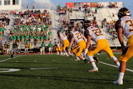 High school football players line up for an onside kick.