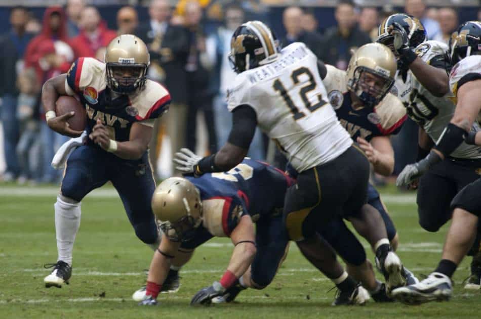 A college football running back from Navy looks to run the ball outside.