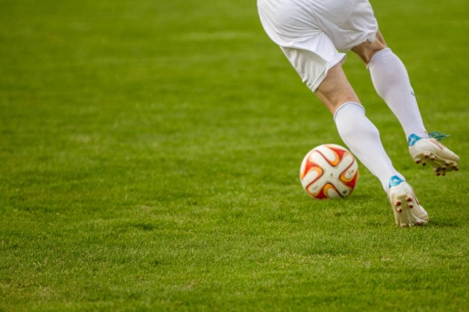 A soccer player dribbles the ball.