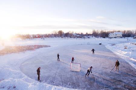 A group of people playing pond hockey.