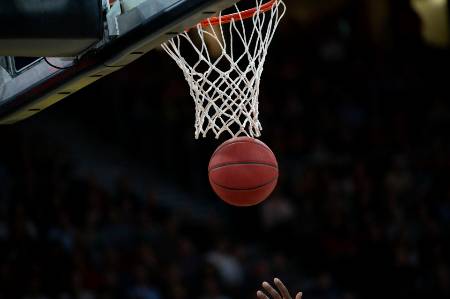 A basketball going through the hoop.