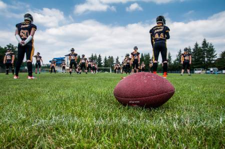 Youth football players line up for stretching.