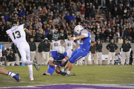 A college football kicker attempts a PAT.