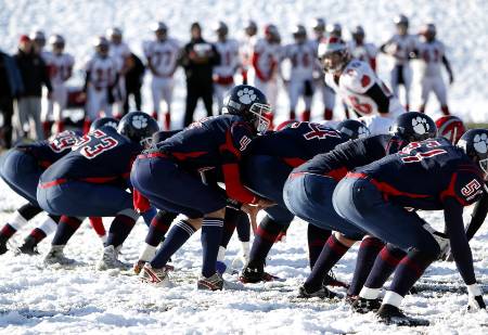 The quarterback tries drawing the defense offsides with a hard count.