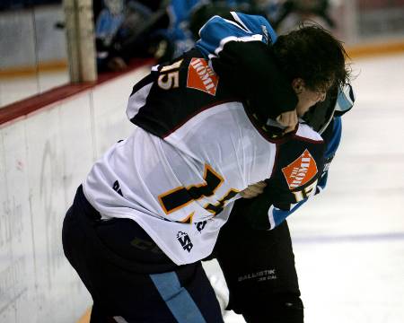 Two professional hockey players fighting.