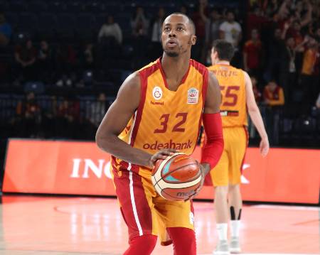 A basketball player practices his shot before a game.