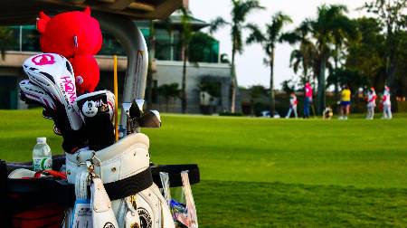 A golf bag with golfers in the background.