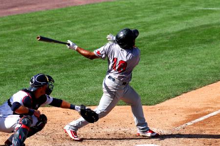 An MLB player holds his follow through after hitting the ball.