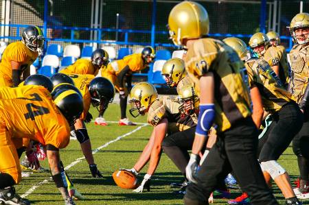 Both football teams line up at the line of scrimmage.