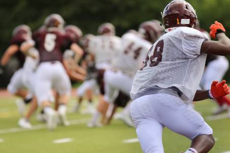 A football safety starts running toward the line.