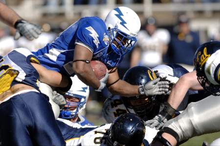 A college football player dives into the end zone to convert on a 2 point conversion.