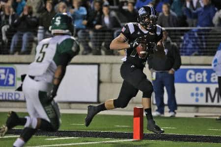 A football player jogs into the end zone.