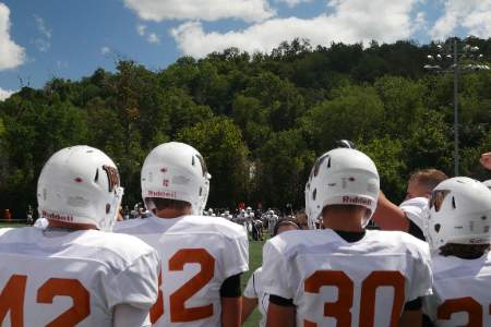 Football players line up on the sideline during a game.