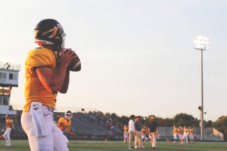 Quarterback dropping back to throw a pass during warmups.