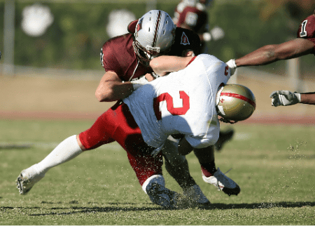 A high school linebacker lays a huge hit on the ball carrier.